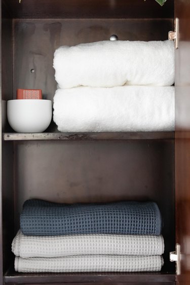 bathroom cabinet with folded towels