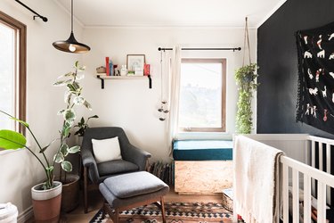 Nursery with grey chair and white and black painted walls