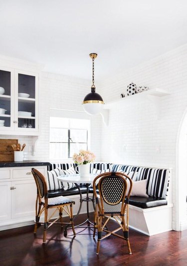 Kitchen with white tile, booth, black and white cushions, black and white pendant