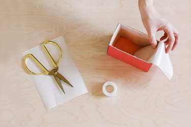 Folding strip of paper over side of box