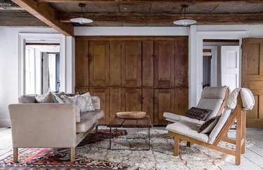 rustic small living room idea with wood ceiling and layered rugs