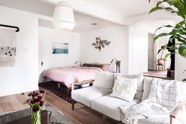 Bedroom with pink linen bedding and white couch