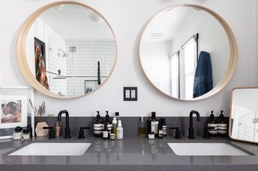 stone vanity countertop, two bathroom sinks and two circular mirrors