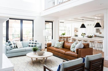 Traditional white living room with brown leather sofa and round coffee table