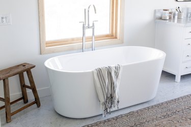 stand alone tub in front of a window