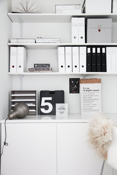 Black-and-white folders on a white desk with graphic accents