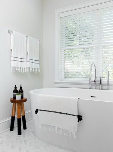 white bathroom trend with freestanding bathtub and Turkish towels