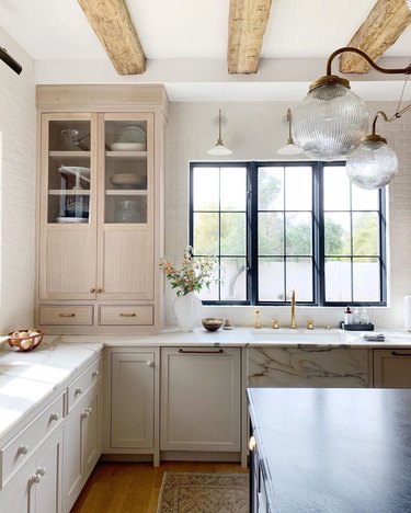 neutral tall kitchen cabinets with rustic wood ceiling beams