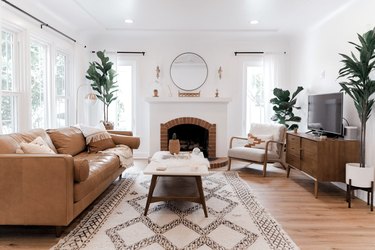 Midcentury modern bohemian living room with leather sofa and potted plants