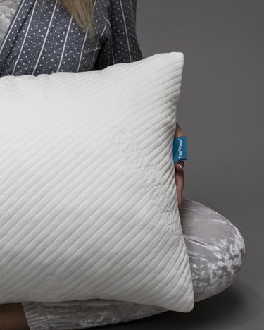person holding a white pillow