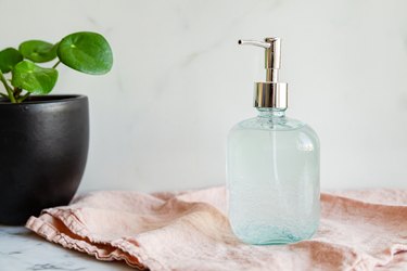 clear bottle with hand pump featuring DIY hand sanitizer on pink towel