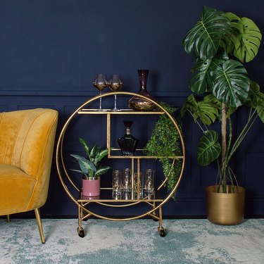 art deco apartment with blue room with brass bar cart