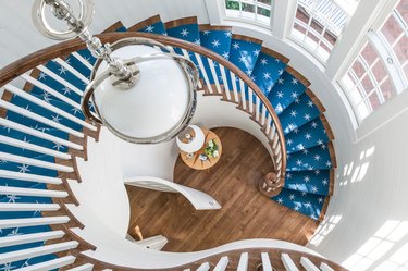 painted white spindles in modern stair railing with blue stair runner