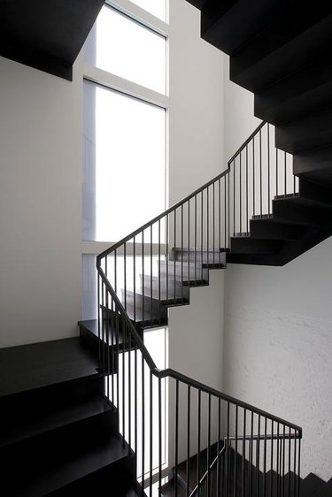 thin black iron modern stair railing with large windows