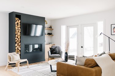 Scandinavian fireplace idea in white living room with stacked wood