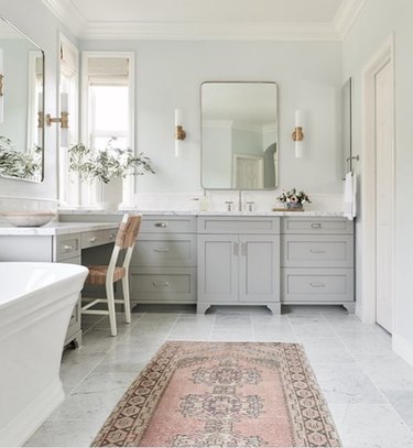 bathroom makeup vanity with gray cabinets and marble countertop