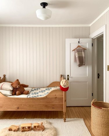Kids' minimalist bedroom with wood bed and vintage decor