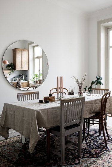 Scandinavian farmhouse style dining room with mismatched chairs and linen tablecloth