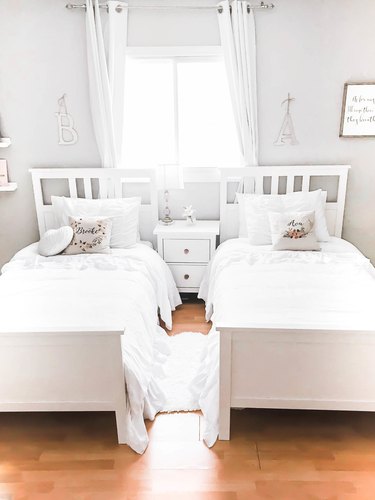 Kids' minimalist bedroom with white beds and throw pillows