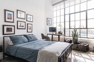modern industrial bedroom with large steel windows and metal bed frame
