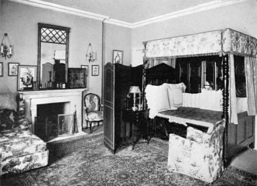 black and white photograph of a bedroom space with patterned rug and chairs