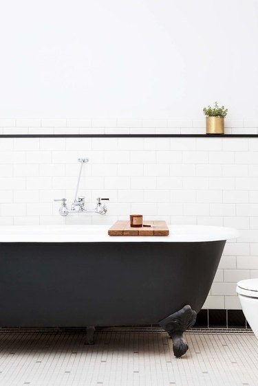 industrial chic bathroom with claw foot tub black-and-white subway tile