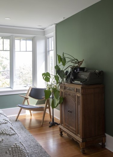 arts and crafts interior of bedroom with green wall and wood cabinet