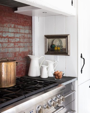 Farmhouse kitchen with red brick backsplash and slate countertops