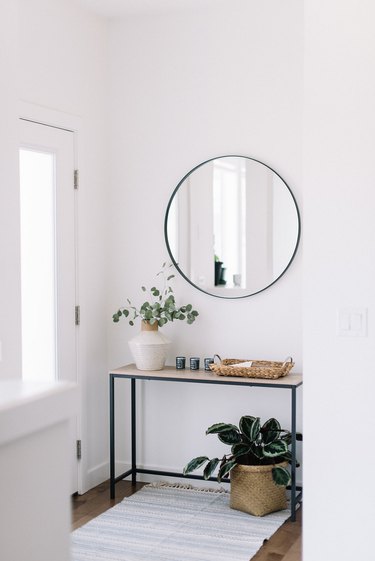 minimalist apartment ideas with white entryway and circle mirror