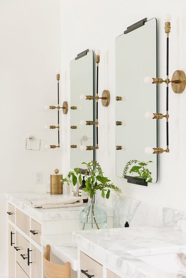 Industrial bathroom mirror lighting ideas above a marble bathroom vanity