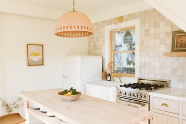 light kitchen, natural tile backsplash and earth-tone pendant light