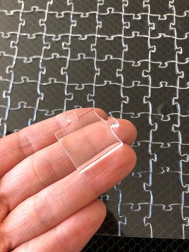 person holding clear puzzle piece over clear puzzle