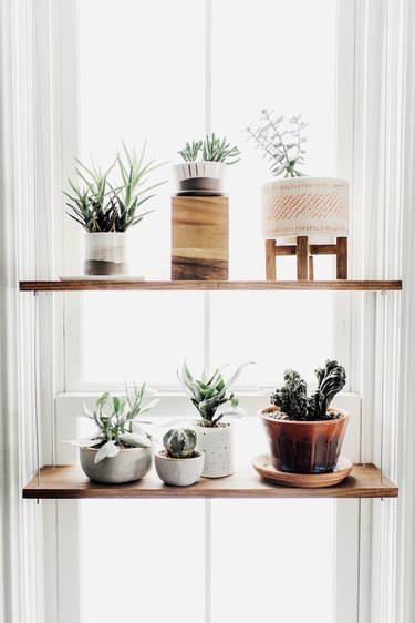 kitchen window idea with hanging shelf with wooden planks and assorted ceramic pots