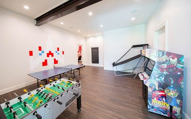 basement game room ideas in white room with light wood floors, arcade game, ping pong table, basketball game, and recessed lighting.