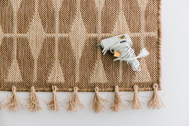 Glue the tassels along the bottom of the rug.