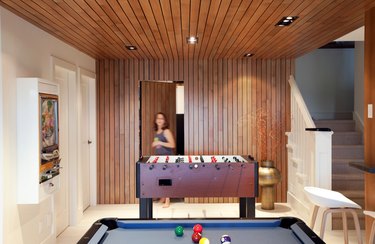 basement game room ideas with wood paneled ceiling and accent wall and pool table