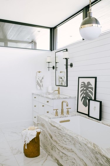 white bathroom idea with marble tub surround and shiplap wall