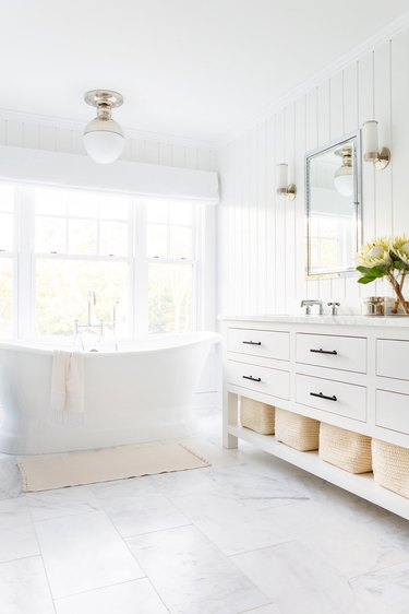 white bathroom idea with tongue and groove wall paneling and freestanding tub