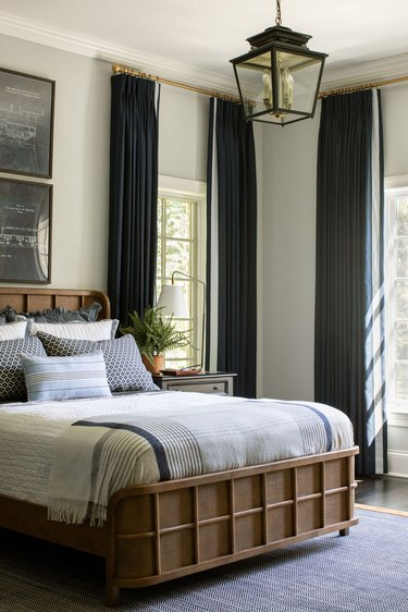 Traditional bedroom with navy blue curtains and lantern-style pendant light