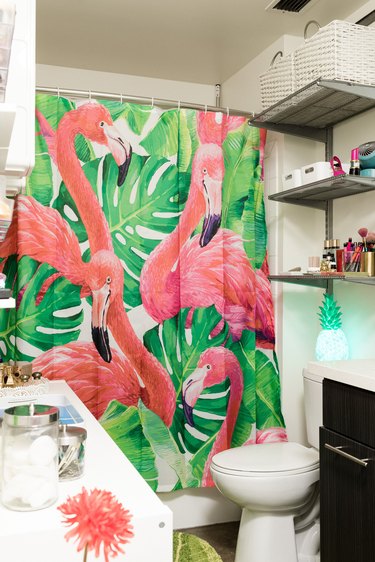 small bathroom with flamingo shower curtain, toilet, over-the-toilet storage and small bathroom vanity with sink