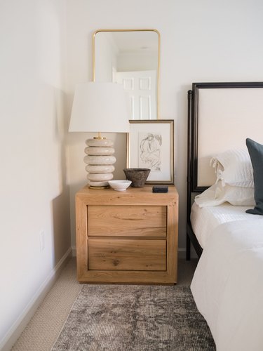 Traditional bedroom with modern lamp and artwork on nightstand