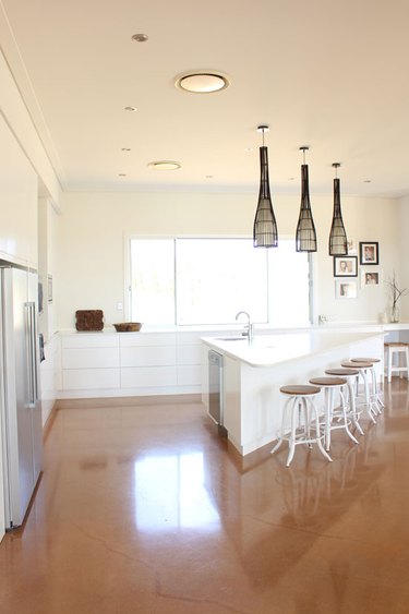 triangle kitchen island in all white space with woven pendant lights