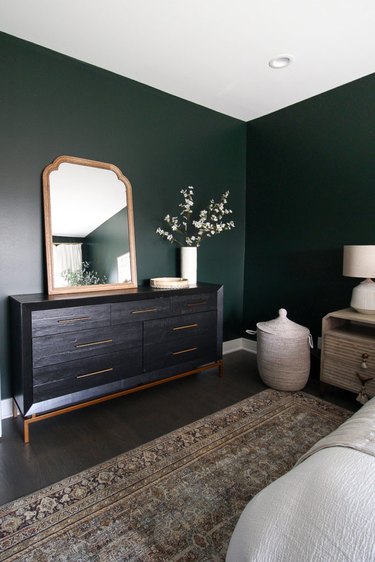 Traditional bedroom with green walls and classic black dresser