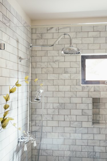 shower with glass wall and grey subway-tile backsplash