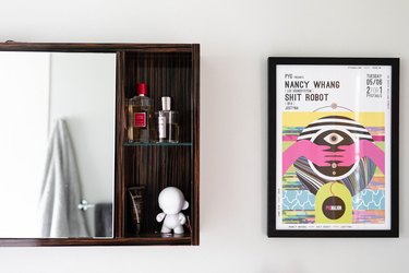 close up of art and dark wood bathroom medicine cabinet