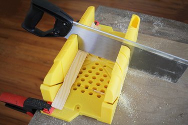 Sawing paint sticks with miter box