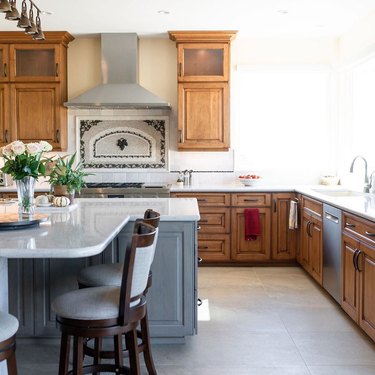 wood cabinets in traditional kitchen with patterned travertine backsplash