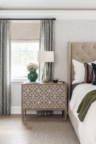 Traditional bedroom with patterned dresser and upholstered headboard