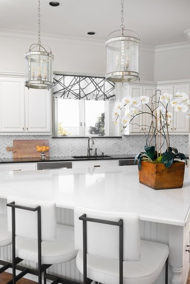 triangle kitchen island in all-white space with white countertop