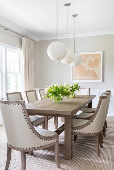 white traditional dining room with wooden table and globe pendant lights